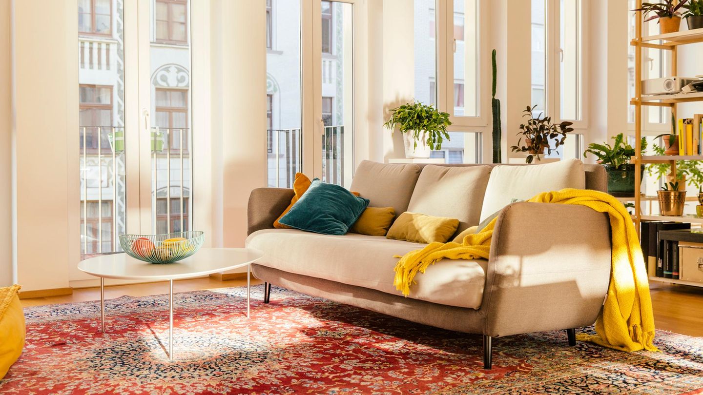 Immobilienkauf Symbolbild: Großzügiges modernes Wohnzimmer in warmen Farben mit Orientteppich