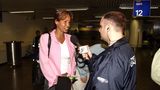 Naddel gibt am Flughafen ein Interview, sie trägt einen rosafarbenen Blazer und spricht in ein Mikrofon