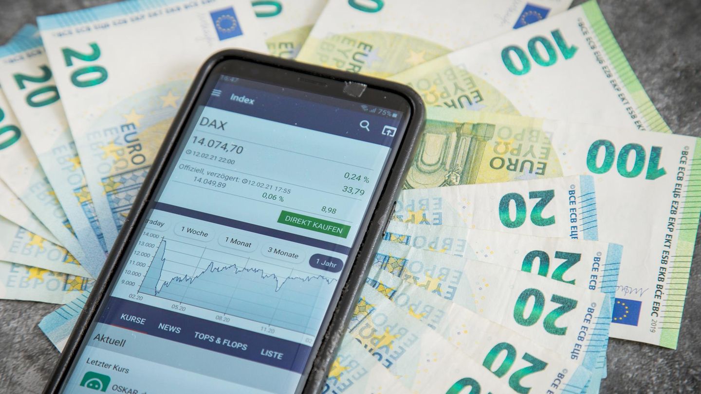 Geldscheine und Smartphone mit geöffneter Börsen-App Geldscheine und Smartphone mit geöffneter Börsen-App