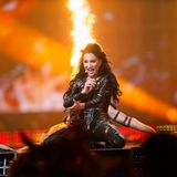 Justyna Steczkowska kniet auf der Bühne, hinter ihr brennen Feuersäulen für die Show