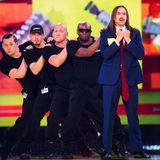 Tommy Cash im blauen Anzug mit seiner Crew auf der Bühne