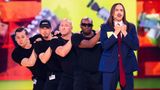 Tommy Cash im blauen Anzug mit seiner Crew auf der Bühne