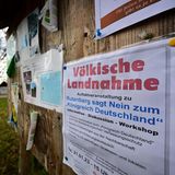 Eine Tafel mit einem Zettel: "Völkische Landnahme" steht darauf