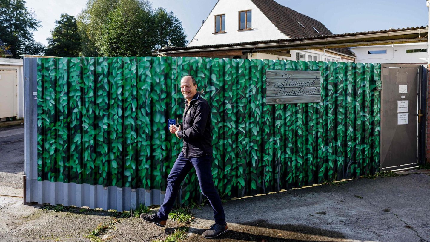 Peter Fitzek steht vor einem Gartenzaun