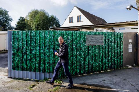Peter Fitzek steht vor einem Gartenzaun
