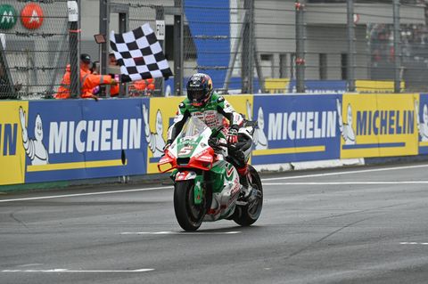 Ein Rennfahrer fährt mit seinem Motorrad über die Ziellinie