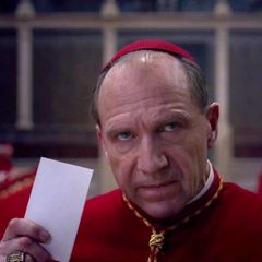 Ralph Fiennes spielt im Film einen Kardinal, der gerade einen Stimmzettel abgibt