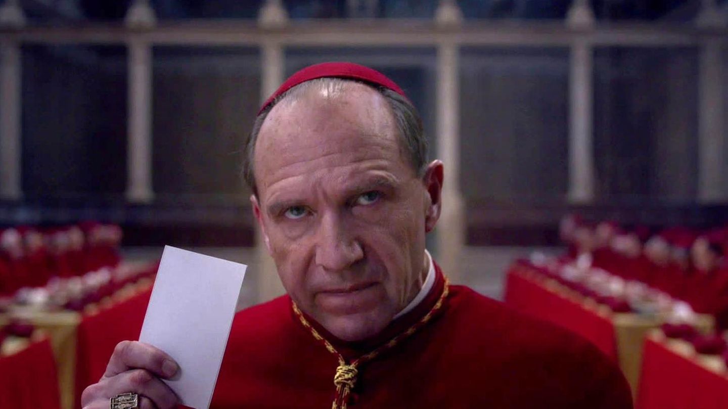 Ralph Fiennes spielt im Film einen Kardinal, der gerade einen Stimmzettel abgibt
