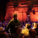 Preisträger Dominic Nahr erhebt sich, um den Preis auf der Bühne entgegenzunehmen