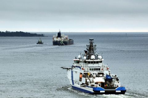 Ein Schiff der finnische Küstenwache eskortiert einen Tanker