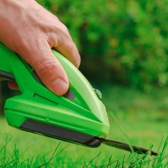 Person nutzt elektrische Gartenschere