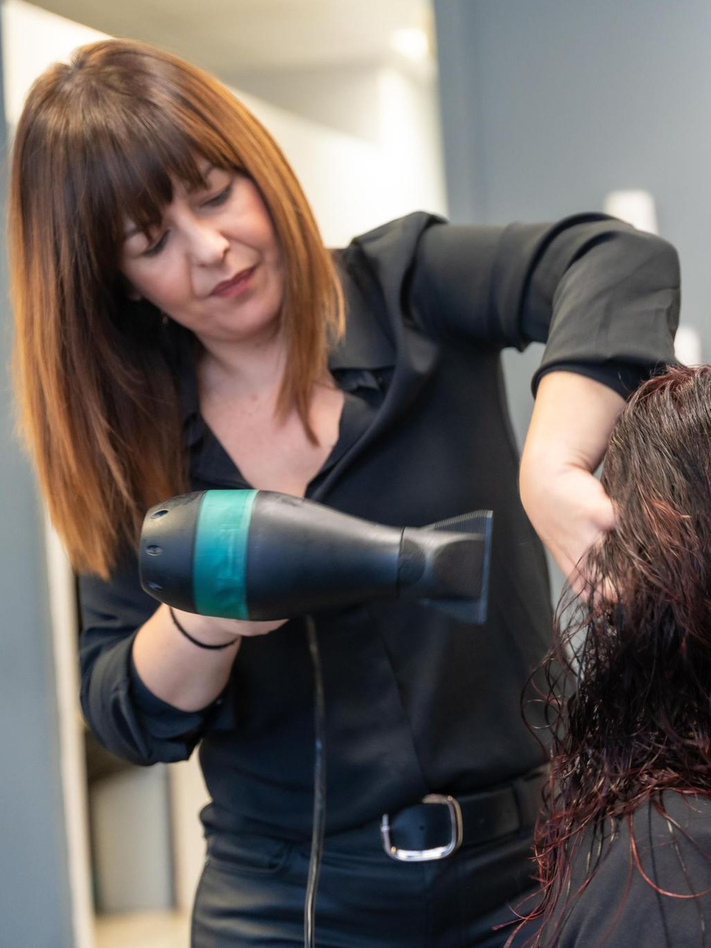 Friseurin stylt Haare ihrer Kundin