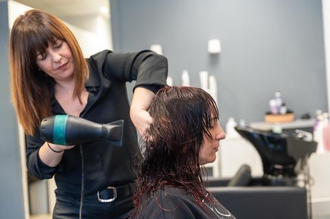 Friseurin stylt Haare ihrer Kundin