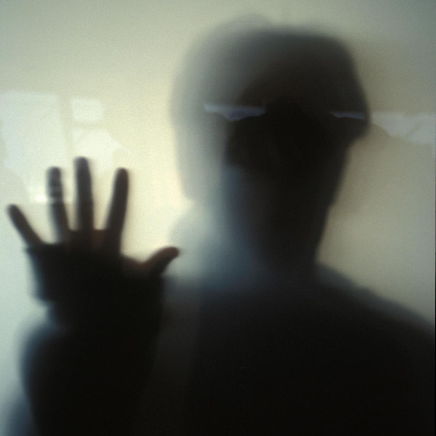 Schatten eines Mannes hinter Glas