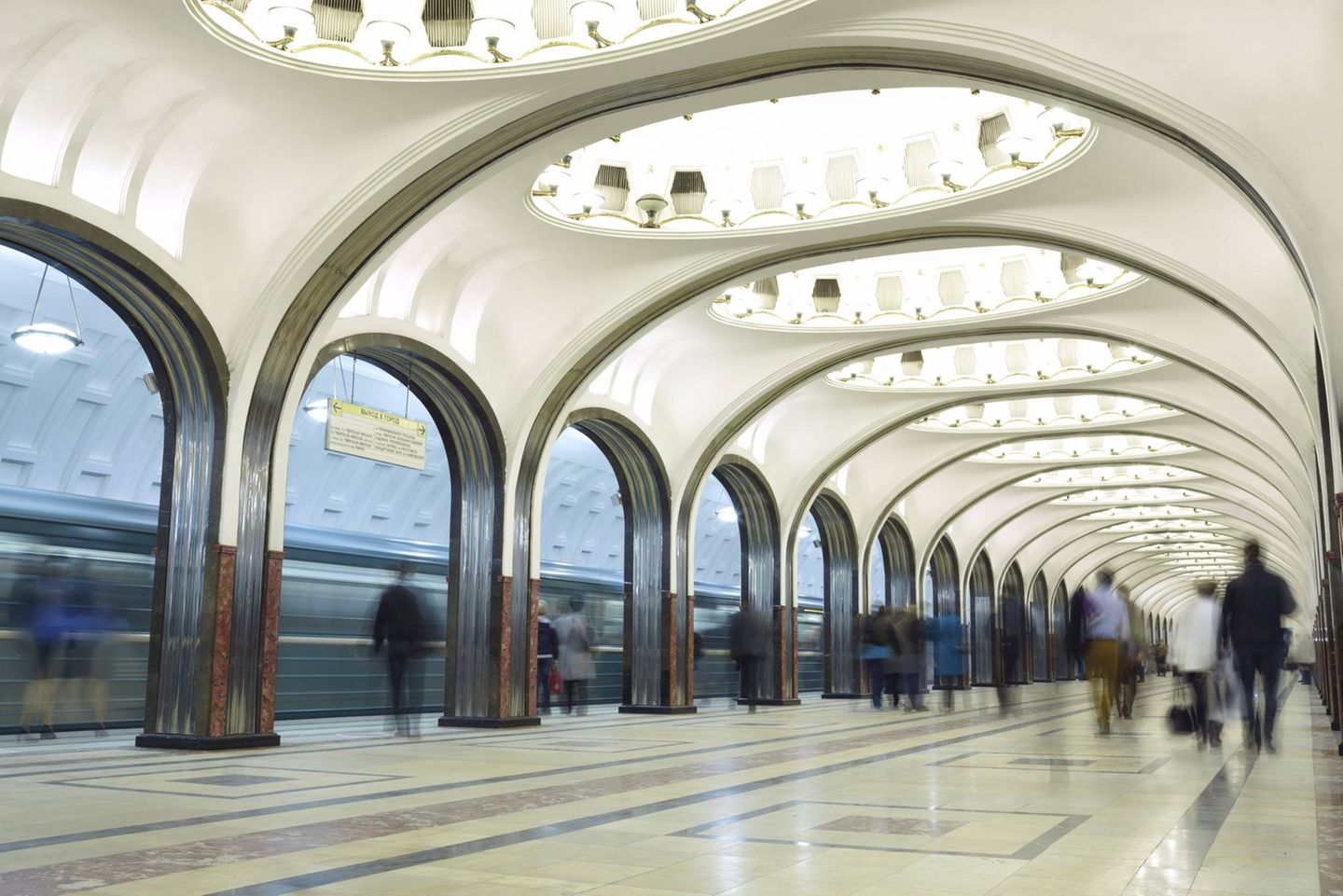 Wandelhallen in der Tiefe Weiße Bögen mit runden Oberlichtern dazwischen überspannen den zentralen Bahnsteig