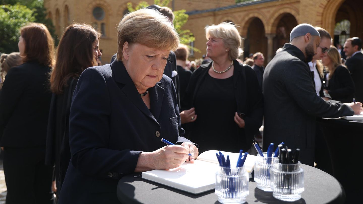 Angela Merkel trägt sich in ein Kondulenzbuch ein