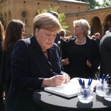 Angela Merkel trägt sich in ein Kondulenzbuch ein