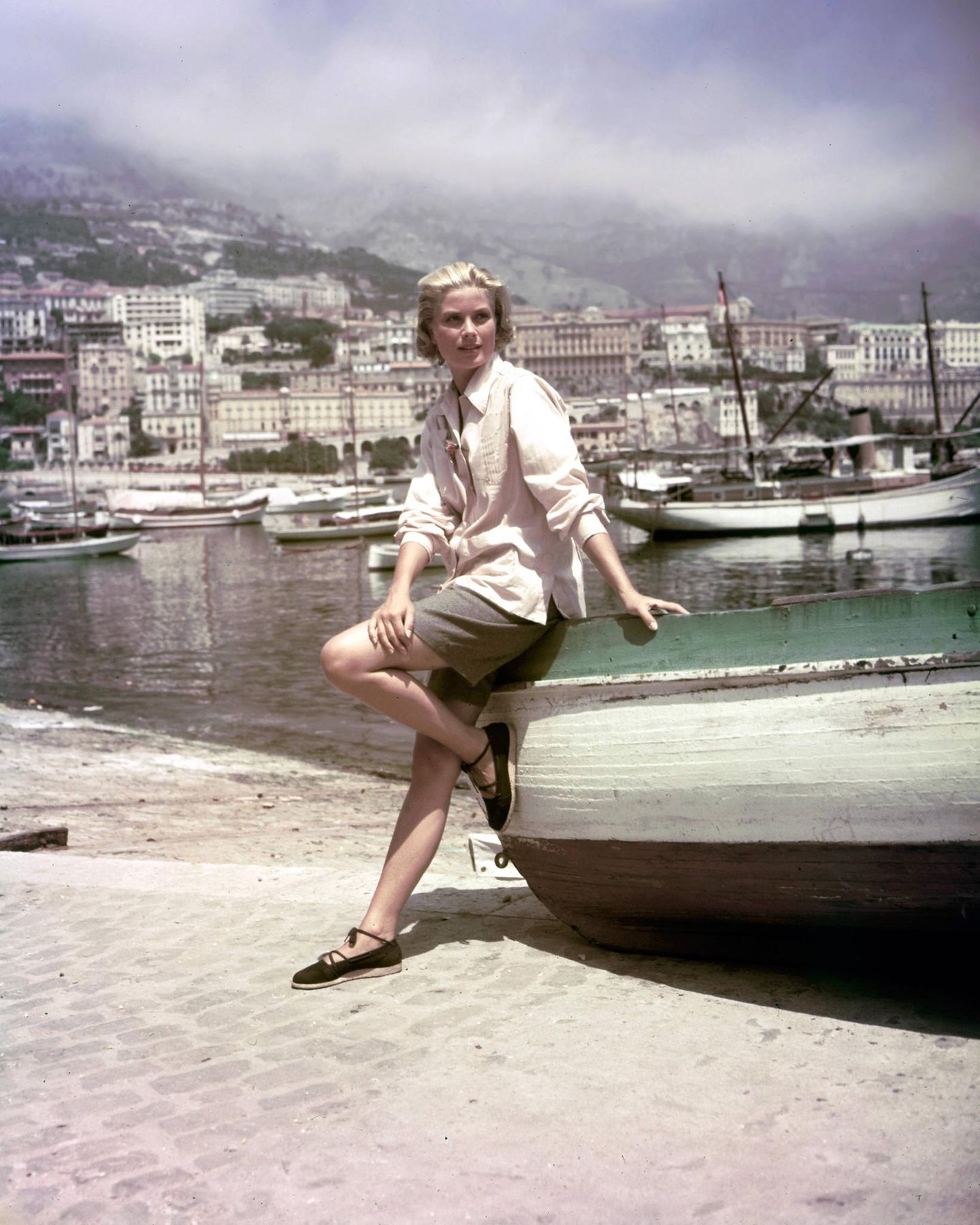 Grace Kelly am Strand von Nizza, sie lehnt an einem Fischerboot