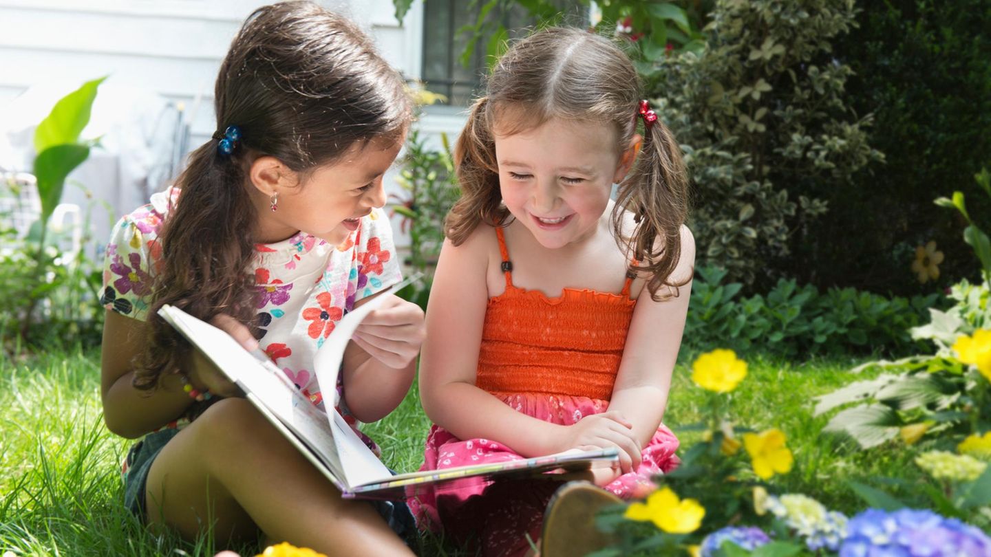 Kinder-Wettbewerb: Eine große Schester liest der kleineren ein Buch vor
