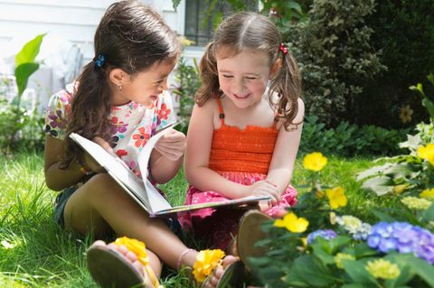 Kinder-Wettbewerb: Eine große Schester liest der kleineren ein Buch vor