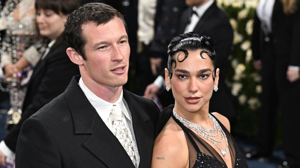 Dua Lipa and her friend Callum Turner at the Met Gala, he in the black suit, she in the black dress without sleeves