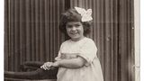 Kinderfoto von Frida Kahlo mit weißer Schelife im langen dunklen Haar