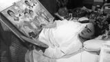 Malerin Frida Kahlo malt liegend im Bett