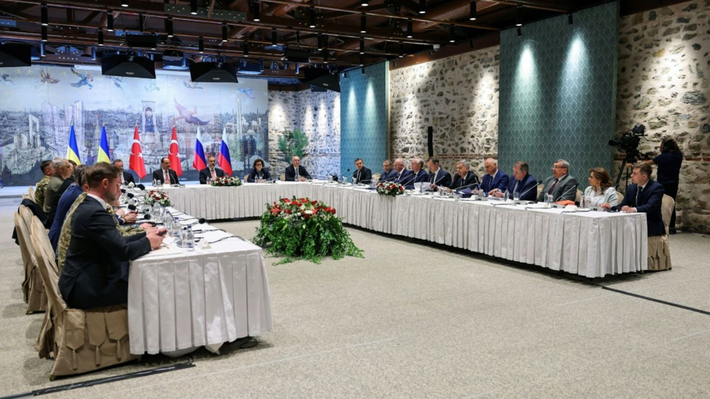 Die Verhandlungsdelegationen der Ukraine (l.) und Russlands (r.)