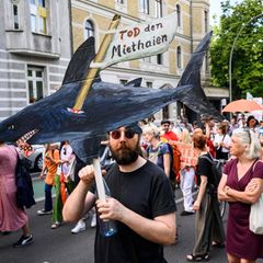 Ein Mann hält einen selbstgemalten Miethai in die Höhe: Demonstration für günstige Wohnungsmieten in Berlin
