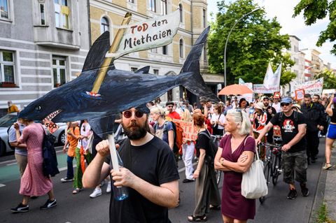Ein Mann hält einen selbstgemalten Miethai in die Höhe: Demonstration für günstige Wohnungsmieten in Berlin
