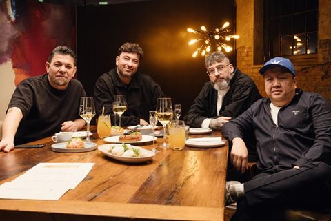 Am Kitchen Impossible Tisch sitzen vier Männer, zwei Köche und zwei Rapper