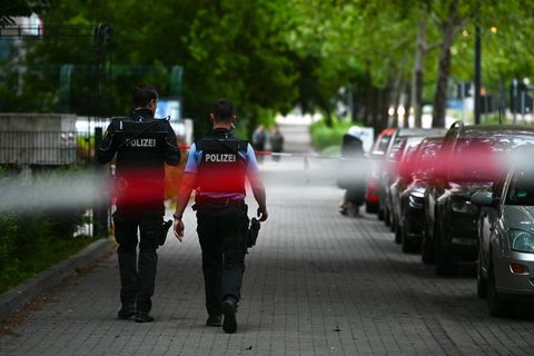 Polizisten marschieren am Tatort der Attacke in Halle entlang