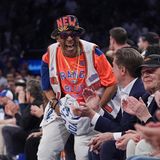 Spike Lee im orangefarbenen Knicks-Trikot springt von seinem Platz auf und freut sich