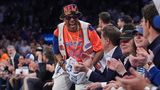 Spike Lee im orangefarbenen Knicks-Trikot springt von seinem Platz auf und freut sich