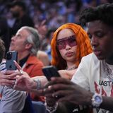 Rapperin Ice Spice mit orangefarbenem Haar hält ihr Handy hoch und mach ein Selfie von sich