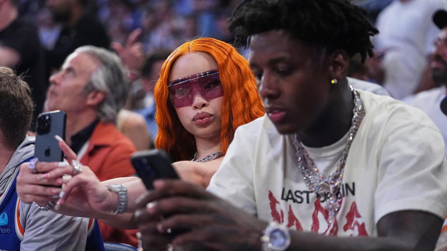 Ein Selfie muss sein Rapperin Ice Spice mit orangefarbenem Haar hält ihr Handy hoch und mach ein Selfie von sich