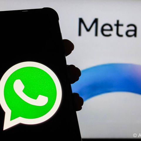 Ein Handy Display mit WhatsApp-Symbol wird vor das META AI-Symbol des Facebook-Konzerns gehalten