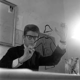 Yves Saint Laurent als junger Man beim Zeichnen eines Kostüms