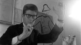 Yves Saint Laurent als junger Man beim Zeichnen eines Kostüms