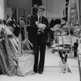 Yves Saint Laurent 1982 in seinem Atelier. Er hält ein Hündchen auf dem Arm