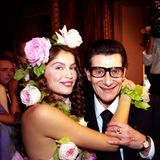 Das Model Laetizia Casta umarmt Yves Saint Laurent, der eine Brille mit dunklem Rahmen trägt