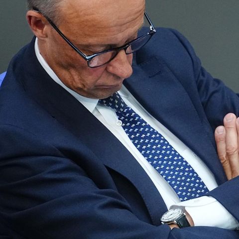 Friedrich Merz sitzend im blauen Anzug, er scheint zu schlafen