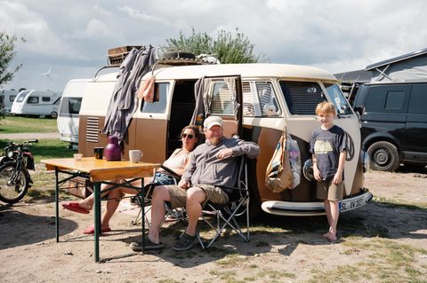Eine Familie sitzt vor ihrem VW Bulli im Ahoi Camp Fehmarn