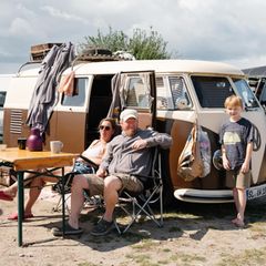 Eine Familie sitzt vor ihrem VW Bulli im Ahoi Camp Fehmarn