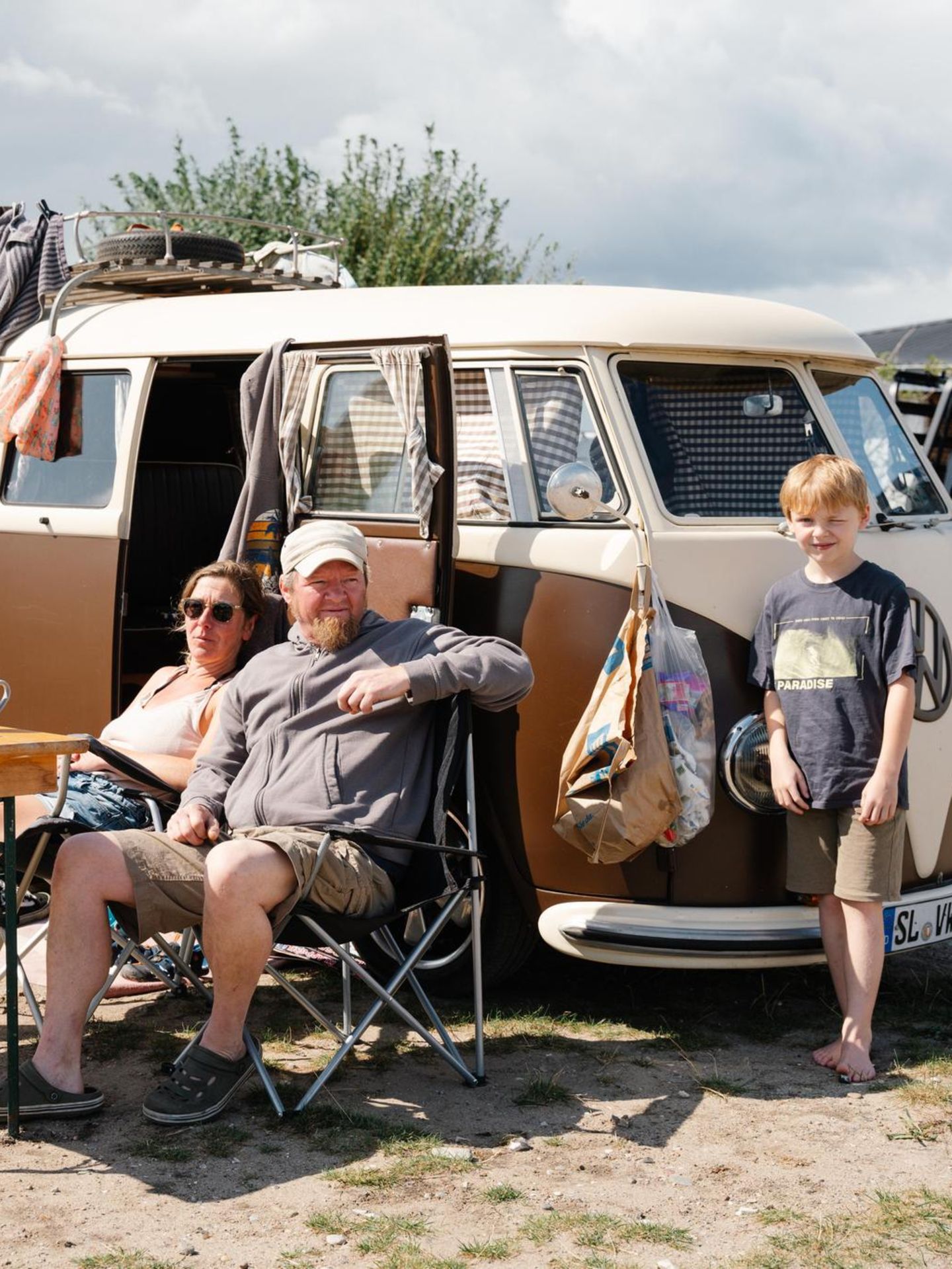 Eine Familie sitzt vor ihrem VW Bulli im Ahoi Camp Fehmarn