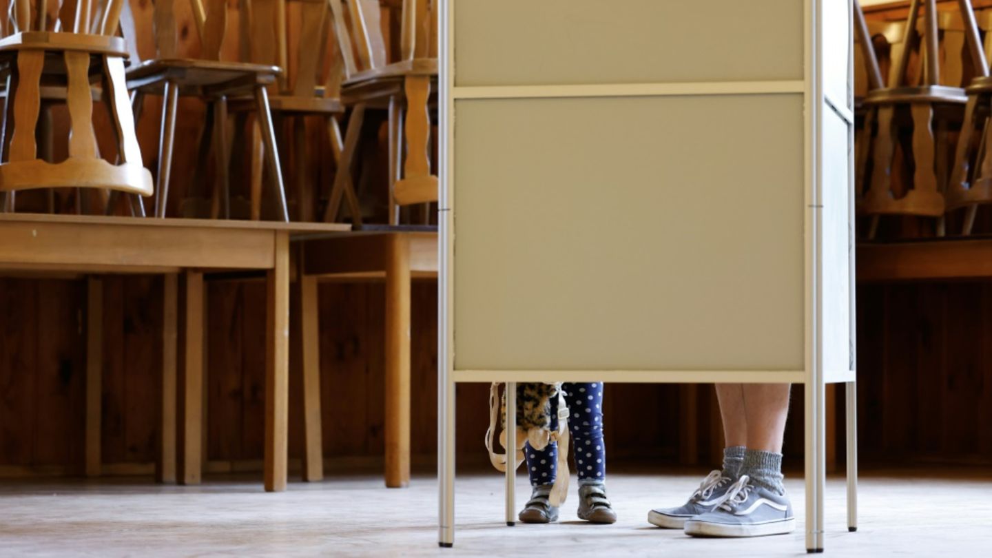 Mann mit Kind in Wahlkabine