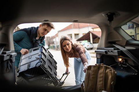 Kofferraum Organizer: Junges Paar packt das Auto