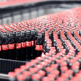 Hunderte 0,33-Liter-Flaschen von Coca-Cola laufen über ein Band