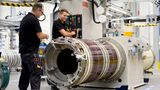 Zwei Siemens-Mitarbeiter montieren einen Magnetresonanztomographen