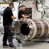 Zwei Siemens-Mitarbeiter montieren einen Magnetresonanztomographen